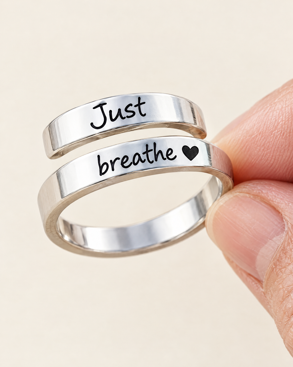 The Breathe Ring, a stainless steel wrap engraved Just breathe with a small heart